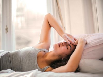 woman in gray tank top lying on bed
